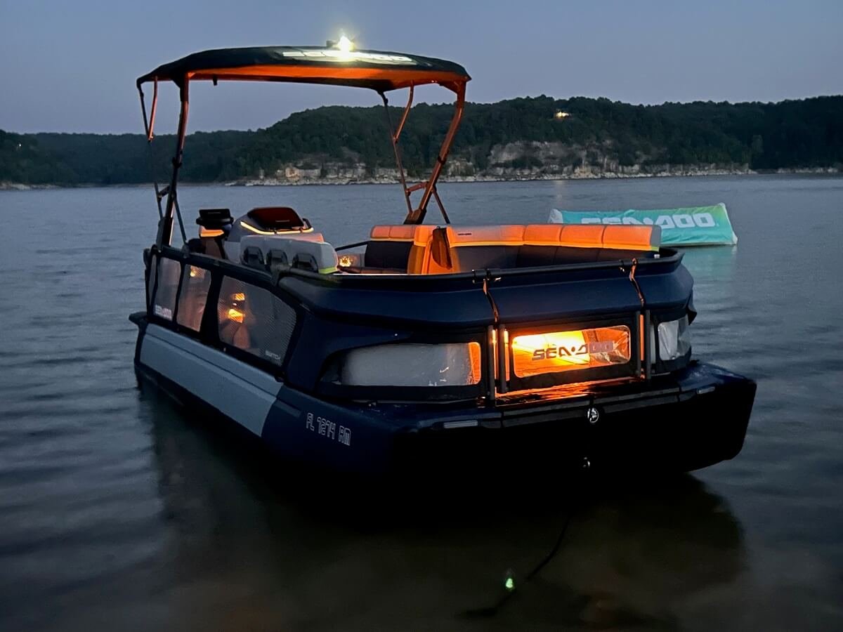 Sea-Doo Switch pontoon lit up on the water at dusk